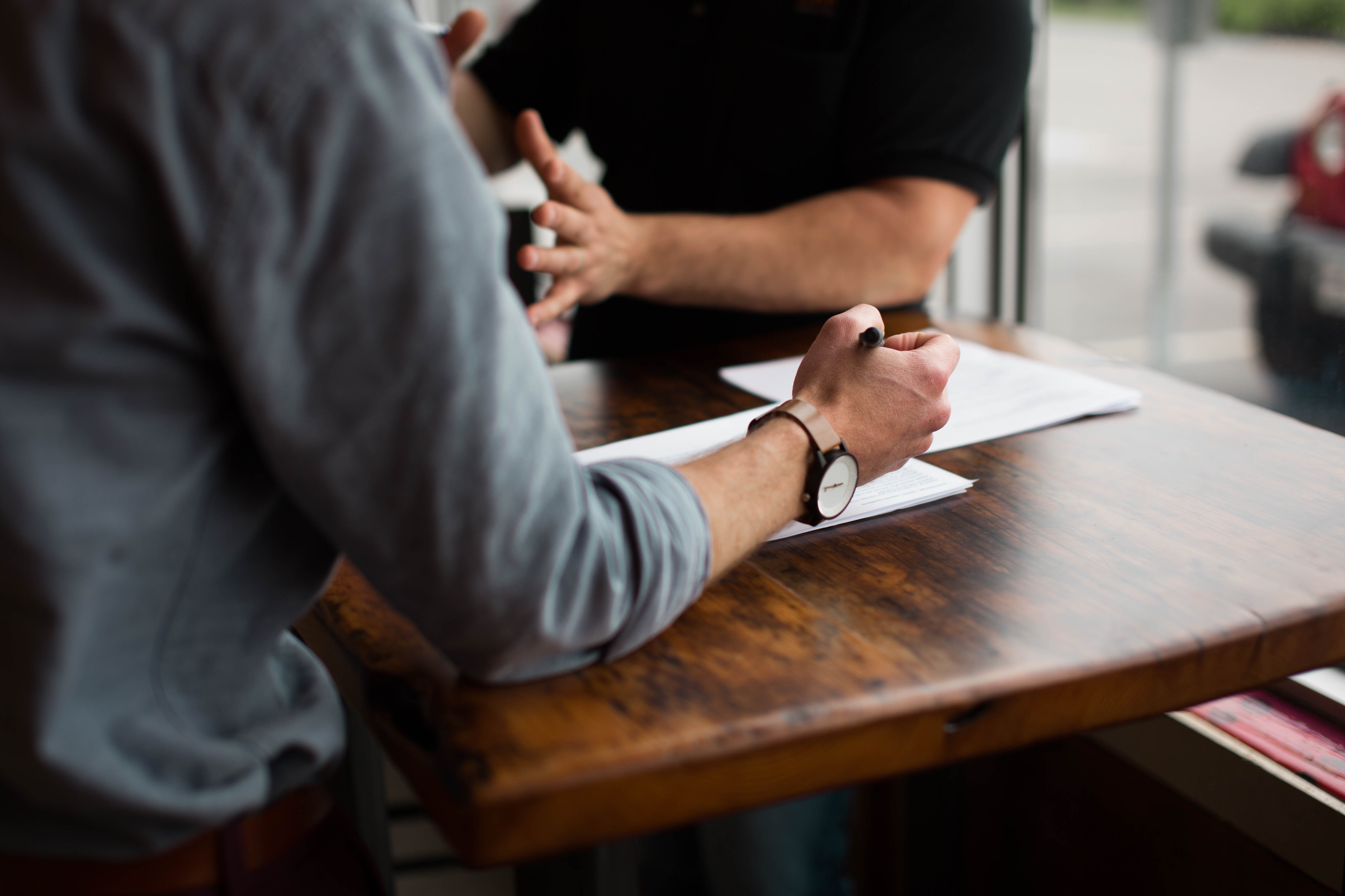 two men sat at a table discussing in a meeting